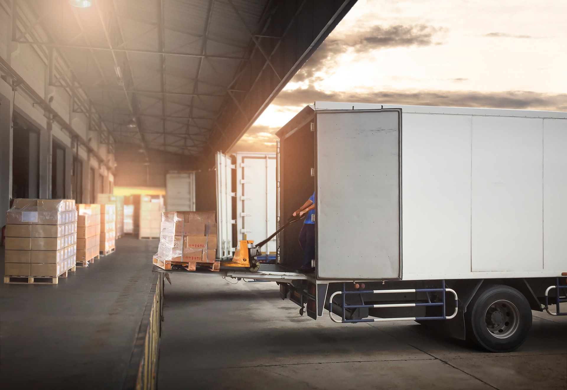 Package Boxes on Pallets Loading into Cargo Container. Trucks Parked Loading at Dock Warehouse. Delivery Service. Shipping Warehouse Logistics. Road Freight Truck Transportation.